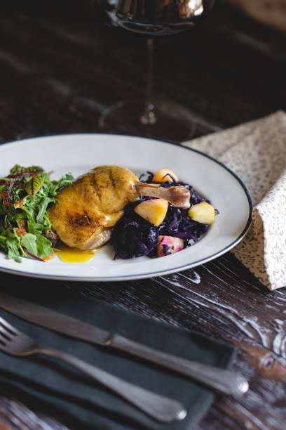 istock Duck leg on a white plate with salad and fresh vegetables 1401753453