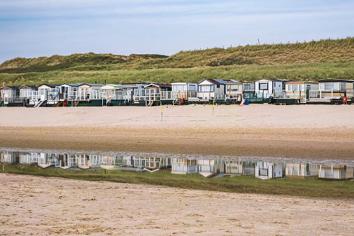 Beach hut and its reflection in the water of the North Sea at low tide near Egmond aan Zee/Netherlands