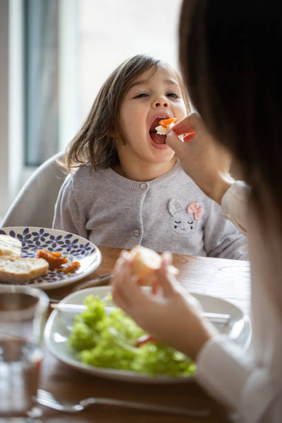 istock Cute little girl sitting at the dining table 1401754664