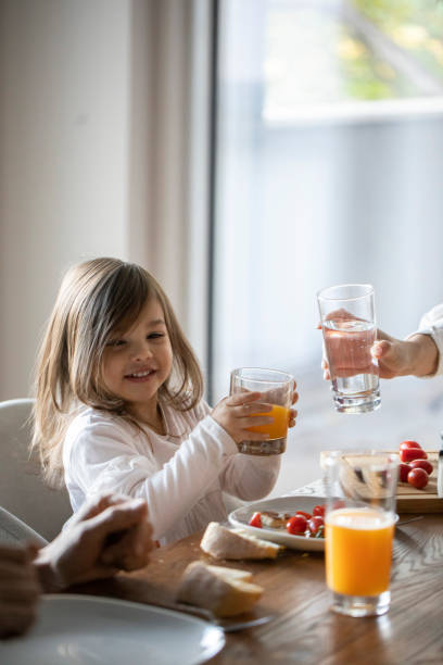 istock Cute little girl sitting at the dining table 1401754671