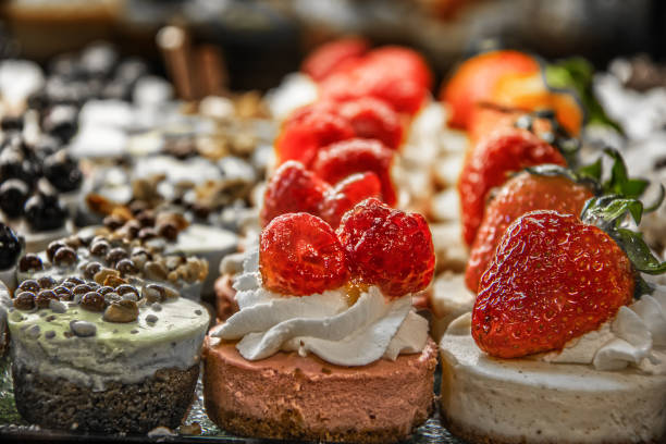 istock Tiny cakes on display with chocolate raspberry and strawberry and whipped cream toppings - Selective focus - Copy Space 1401760919
