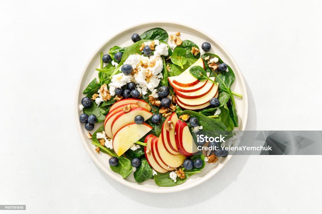 Apple and spinach fresh sweet fruit salad with blueberry, cheese cottage and walnuts, top view Salad Stock Photo