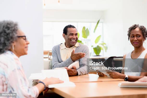 Mature Male Leader Gestures Toward Unseen Person During Discussion Stock Photo - Download Image Now