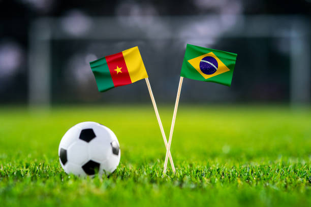 Cameroon vs. Brazil, Lusail, Football match wallpaper, Handmade national flags and soccer ball on green grass. Football stadium in background. Black edit space. Cameroon vs. Brazil, Lusail, Football match wallpaper, Handmade national flags and soccer ball on green grass. Football stadium in background. Black edit space. cameroon stock pictures, royalty-free photos & images