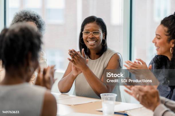 Group Of Employees Smile And Applaud After Successful Year Stock Photo - Download Image Now