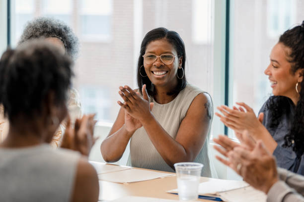 group of employees smile and applaud after successful year - women businesswoman business mature adult imagens e fotografias de stock