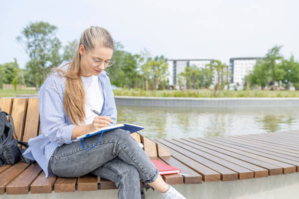 istock Young woman sitting outdoors and studying 1401768650