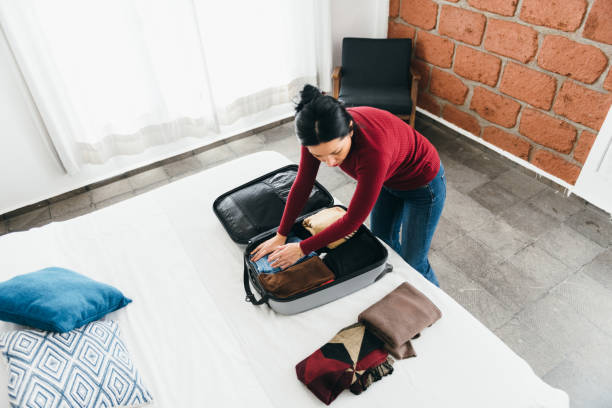 istock Woman unpacking a suitcase in hotel room 1401768998