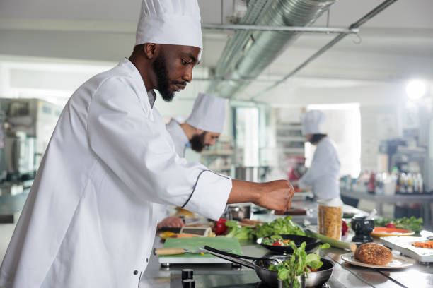 istock Food industry expert adding fresh green herbs to improve dish taste 1401771884