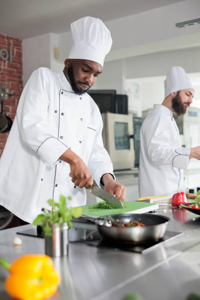 istock Gastronomic expert in restaurant professional kitchen chopping fresh greens while cooking gourmet dish for dinner service 1401771935