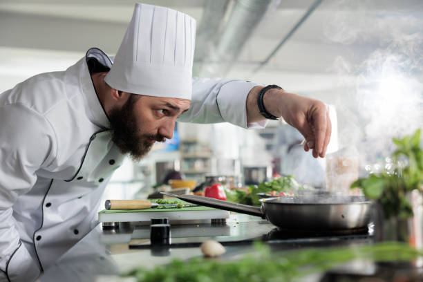 istock Head chef seasoning gourmet dish in pan while cooking fine dining food served at dinner service in restaurant 1401772020