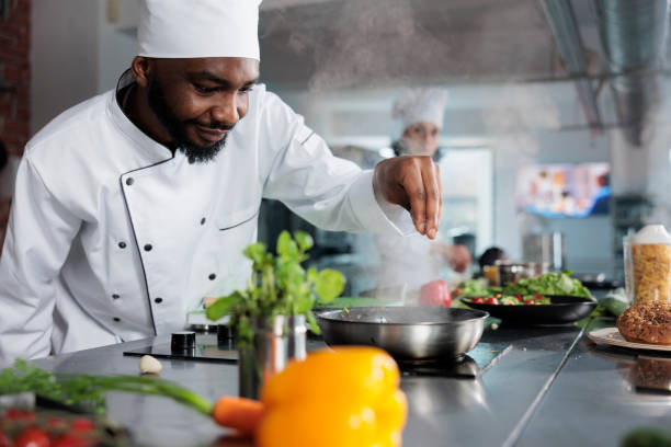 Skilled gastronomy expert garnishing gourmet dish with parmesan cheese in restaurant professional kitchen Skilled gastronomy expert garnishing gourmet dish with parmesan cheese in restaurant professional kitchen. Cuisine chef preparing food using fresh herbs and organic vegetables. chef stock pictures, royalty-free photos & images