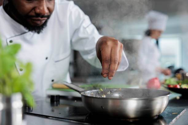 istock Master chef wearing cooking uniform garnishing gourmet dish with fresh chopped herbs in restaurant kitchen 1401772073