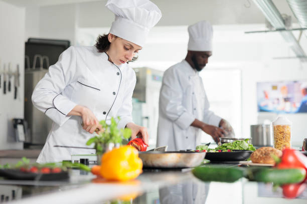 istock Head cook in professional kitchen cooking organic food while cutting fresh vegetables 1401772104
