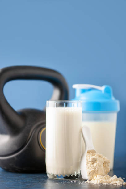 단백질 스포츠 쉐이크와 블루 배경에 무게. 피트니스 음식과 음료. 다이어트. 복사 공간 - whey protein isolate 뉴스 사진 이미지