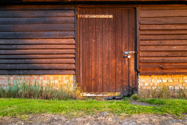 Shut and locked barn down seen during the sunset, helping to create a warm atmosphere to the image. The barn is used to house livestock.