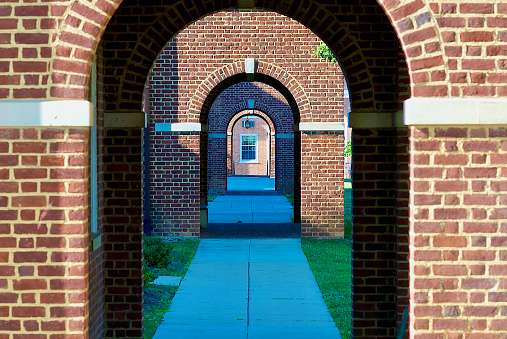 Fairfax, Virginia, USA - June 26, 2017: View looking through multiple archways along the front walkway of the Historic Fairfax Court House in the City of Fairfax, Virginia.