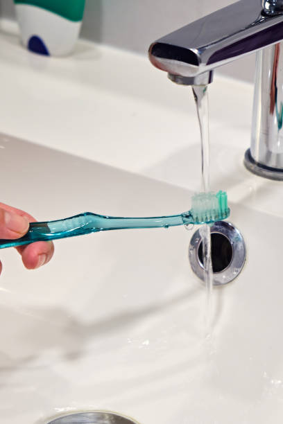 istock Toothbrush under a stream of water in a washbasin 1401778992