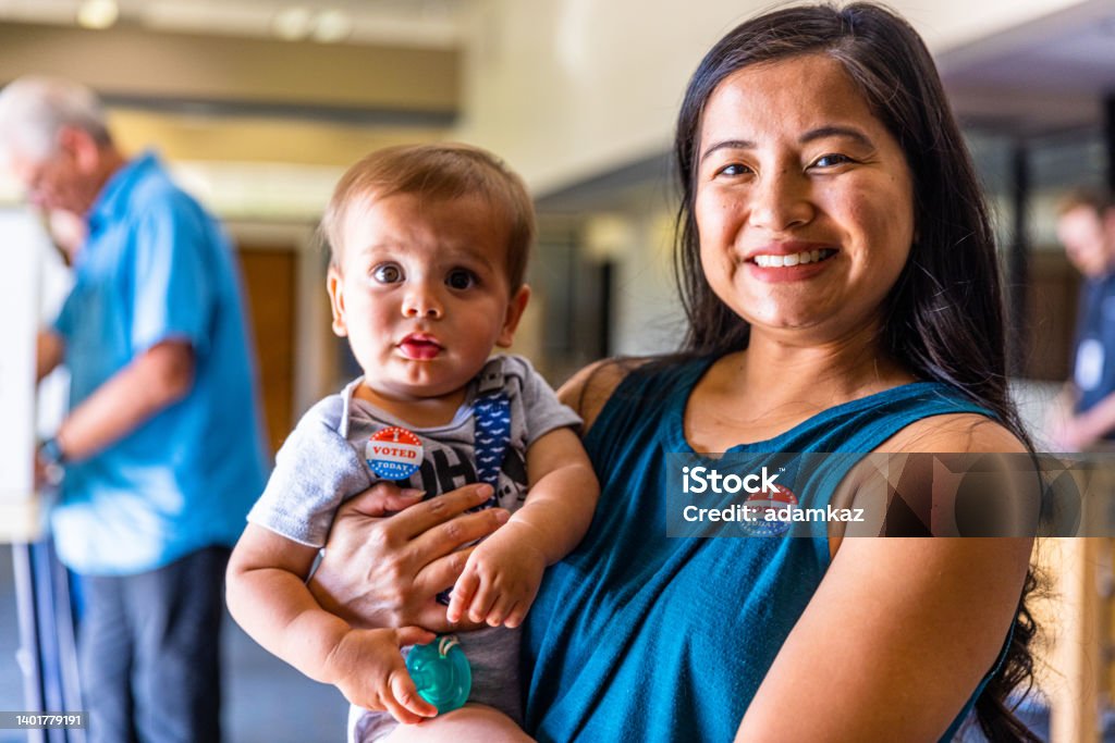 Filipino Woman and her baby boy after voting in an American Election Americans Voting in an Election Voting Stock Photo