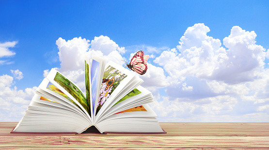 Book of nature. Horizontal banner with book open and butterfly on wood table. Knowledge, education, ecology and environment concept. Copy space for text