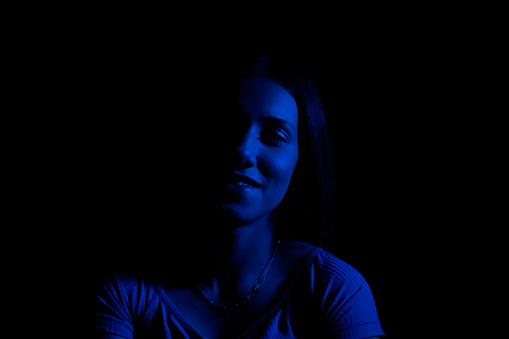 Woman with green and dark blue gel lighting.