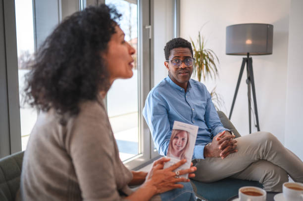 homem negro adulto médio apoiando sua esposa latina na nomeação de cirurgiões plásticos - lobby office indoors waiting room - fotografias e filmes do acervo