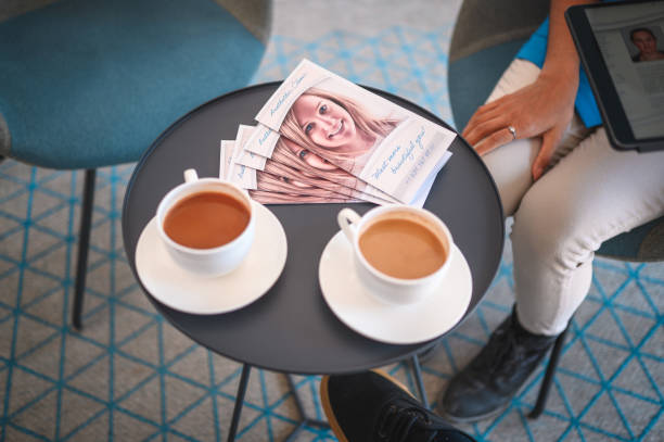 duas xícaras de café e folhetos hospitalares privados na mesa - lobby office indoors waiting room - fotografias e filmes do acervo