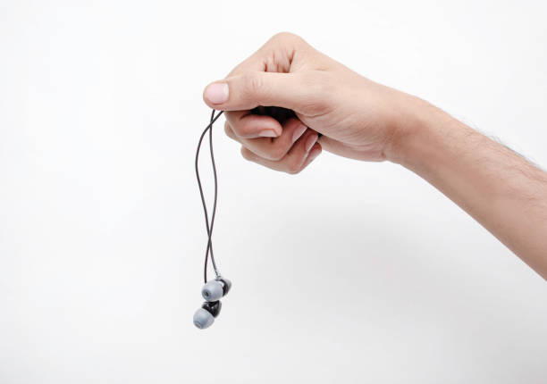 istock Hand holding wired headphones on a white background 1401787705
