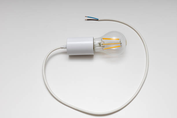 istock an electric lamp screwed into a socket with a cable lies on a white 1401788620