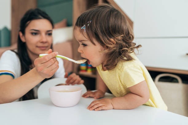 istock Mother feeding her girl 1401788853