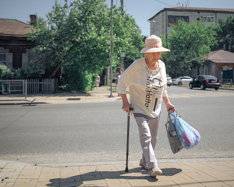 25 th of May, Russia, Tomsk, older woman with a hat walks on street editorial
