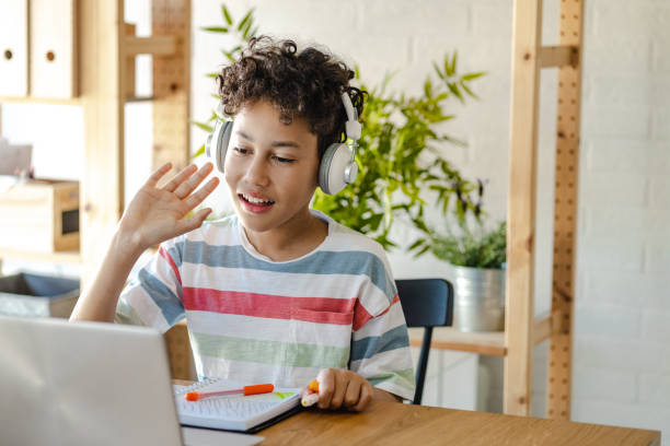 istock Little boy using laptop at home and communicating on a video call 1401792232