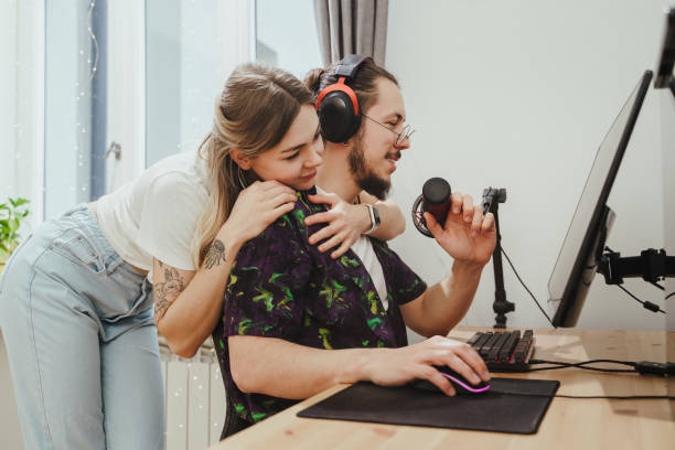 istock Guy blogger and his beautiful girlfriend at the desk with personal computer 1401793462