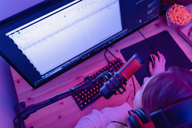 istock Woman blogger using condenser microphone during online podcast in room with neon light 1401793541