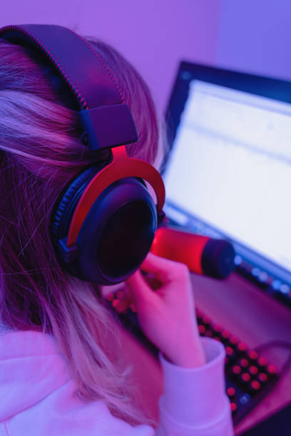 istock Woman gamer using headphones and personal computer in room with neon light 1401793720