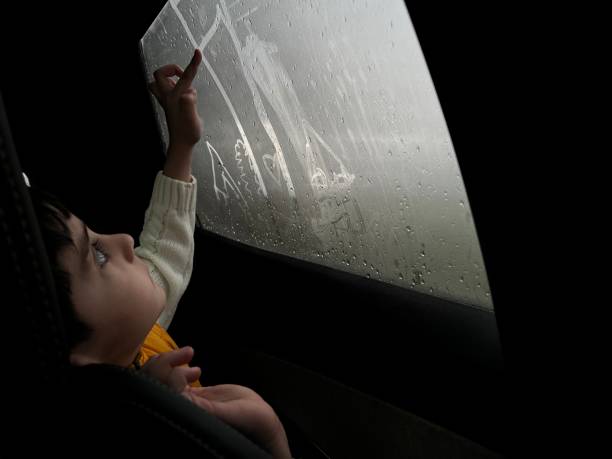 uma criança desenha um coração com o dedo no vidro embaçado - drop window water fog - fotografias e filmes do acervo