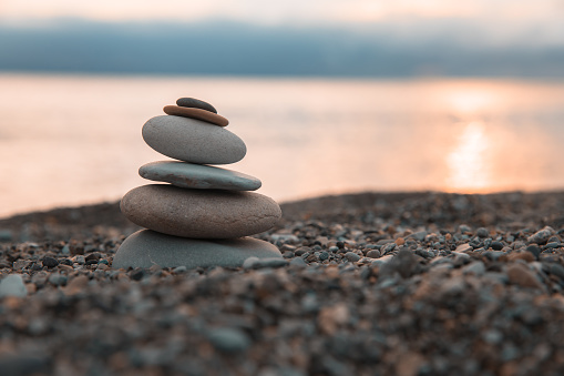 Zen stones on the sea beach at sunset