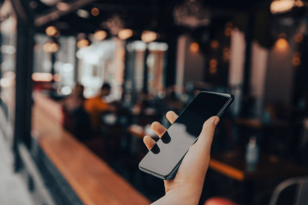 istock man holding smart phone  in cafe 1401795733