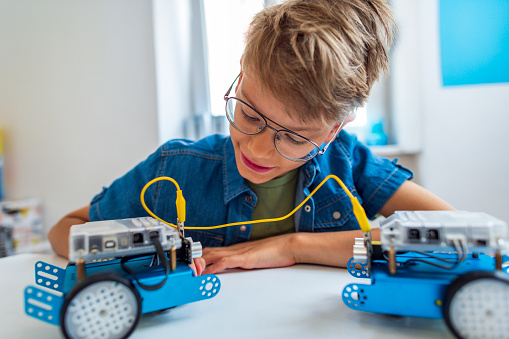 Close-up of a young student in a classroom making a robot