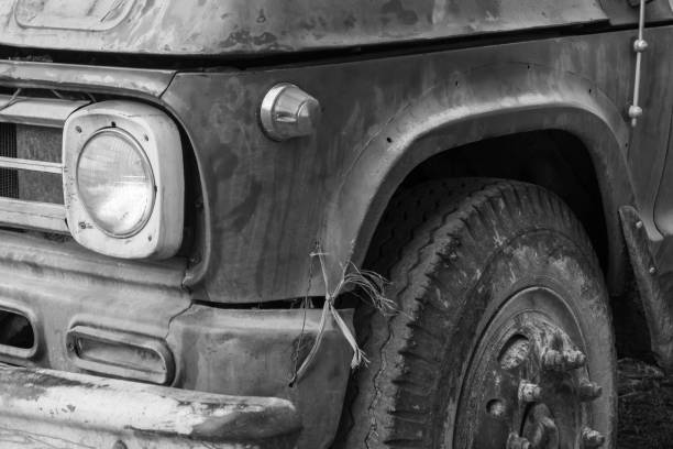 Old truck detail in rural area. Highlighted front and headlight. Black and withe photo.