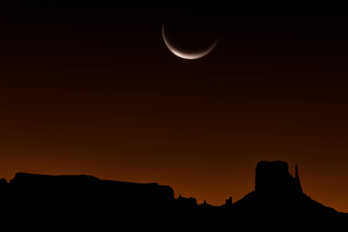 Crescent moon over Monument Valley, AZ