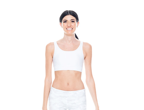 One person of aged 20-29 years old who is beautiful with long hair caucasian young women sportsperson standing in front of white background wearing spandex with hand by side
