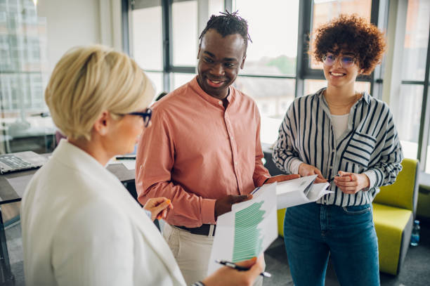 istock Multiracial business colleagues discussing about documents in the office 1401807574