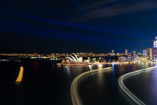 Sydney, Australia - May 31, 2022: Sydney Opera House lights up with ferry light trails during Vivid Sydney.