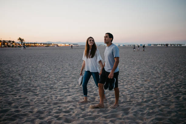 istock A man and his girlfriend are strolling on a sandy beach at twilight in Spain. 1401809940