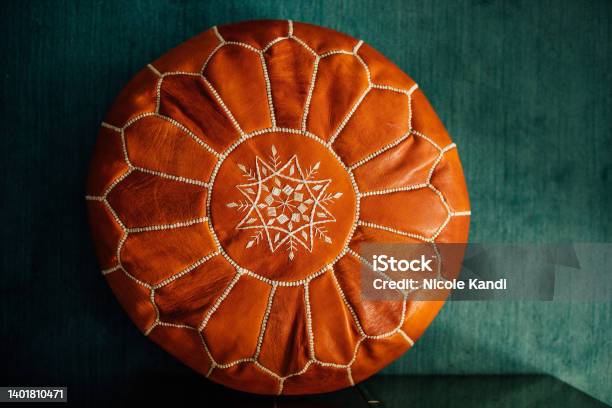 Brown Leather Moroccan Pouf On Teal Carpet Stock Photo - Download Image Now - Hassock, Moroccan Culture, Leather