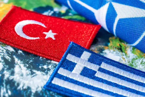 Photo of 8 June 2022 The flag of Turkey and Greece against the background of the NATO symbol, Concept, Growing conflict between the members of the North Atlantic Treaty on the islands in the Aegean Sea