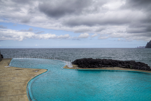 Pool by the sea, with clouds on the horizon. Porto da Cruz - Madeira