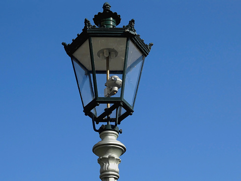 A depiction in low-angle view of a vintage gas lantern. photo shot in early June 2022, in Dusseldorf, Germany.