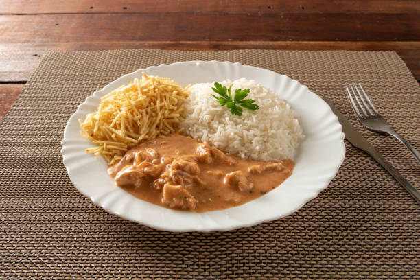 istock Chicken stroganoff accompanied with rice, salad and potato straw. 1401817448